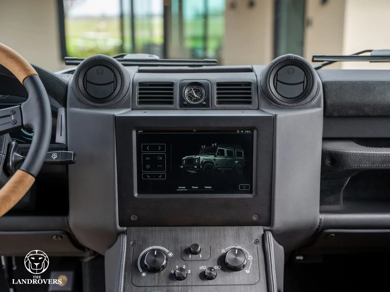 Central touchscreen in The Landrovers’ grey Talus dashboard, showing a vehicle view and control sidebar beside physical controls.